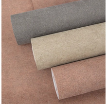 Tři role tapety s jemnou strukturou v šedé, béžové a terakotové barvě.