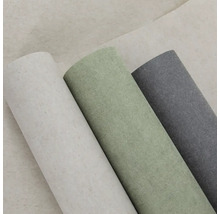 Tři role strukturované tapety v různých barvách vedle sebe.