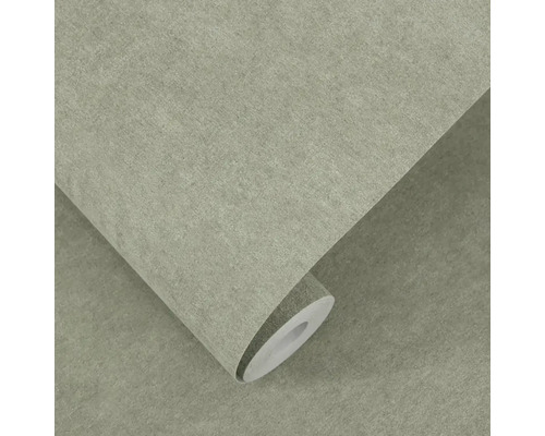 Strukturovaná vliesová tapeta s šedým vzhledem kamene, částečně rozvinutá role tapety pro dekoraci stěn.