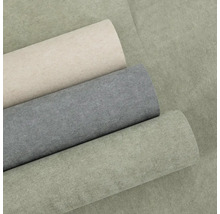 Tři role vliesové tapety se strukturovaným povrchem v různých barvách.