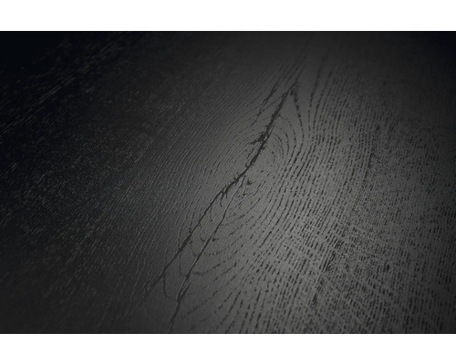 Detailní pohled na tmavý povrch podlahové krytiny s texturou dřeva a viditelným sukem.