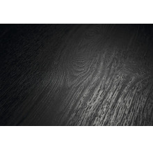 Detailní záběr tmavého povrchu podlahy s dřevěnou strukturou, viditelnou kresbou a suky.