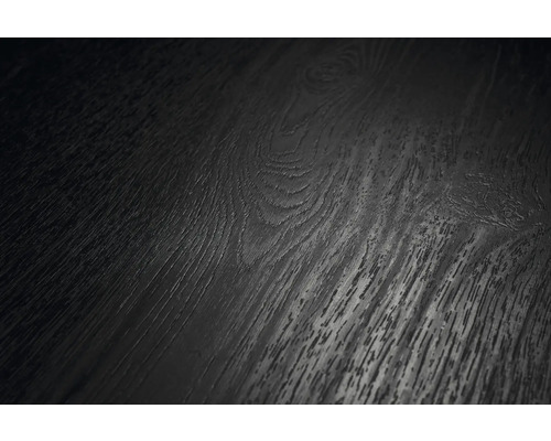 Detailní záběr tmavého povrchu podlahy s dřevěnou strukturou, viditelnou kresbou a suky.