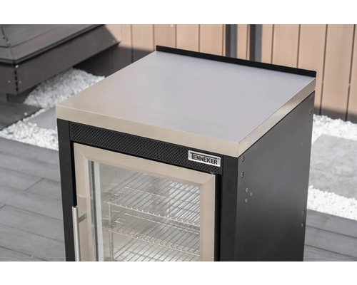 Modul venkovní chladničky Tenneker s pracovní deskou z nerezové oceli a skleněnými dveřmi ve světlé venkovní kuchyni na terase.