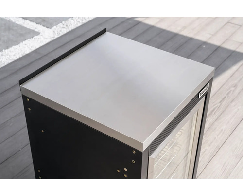 Modul venkovní kuchyně Tenneker s pracovní deskou z nerezové oceli, skleněnými dveřmi a Tenneker Logo na dřevěné terase.