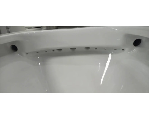 Detailní pohled na bílou keramickou záchodovou mísu se splachovacím kruhem a otvory pro distribuci vody.