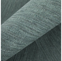 Detailní záběr tmavě zelené strukturované vliesové tapety s diagonálním pruhovaným vzorem.