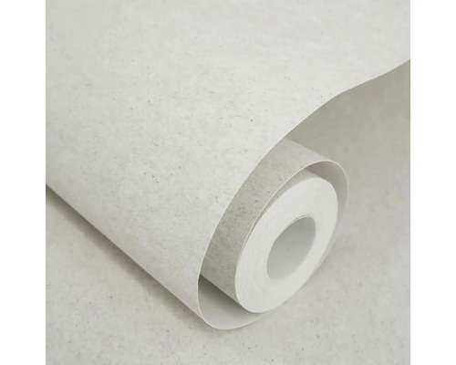 Světle šedá tapeta s jemným tečkováním ve vzhledu recyklovaného papíru, částečně rozvinutá role tapety.