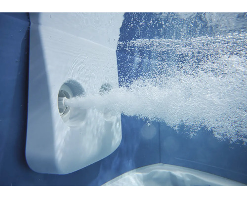 Podvodní záběr masážní trysky bazénu, která do vody vypouští silný proud vzduchových bublin.