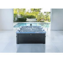 Moderní obdélníková vířivka MSpa s bublinkovou funkcí a opěrkami hlavy ve světlé místnosti s výhledem na bazén a zahradu.