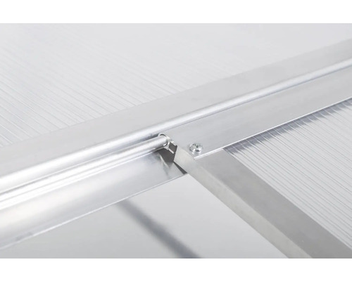 Detailní pohled na upevnění okna skleníku s hliníkovým profilem a polykarbonátovou komůrkovou deskou.