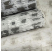 Vliesová tapeta s abstraktním vzorem ikat a strukturovaným povrchem.