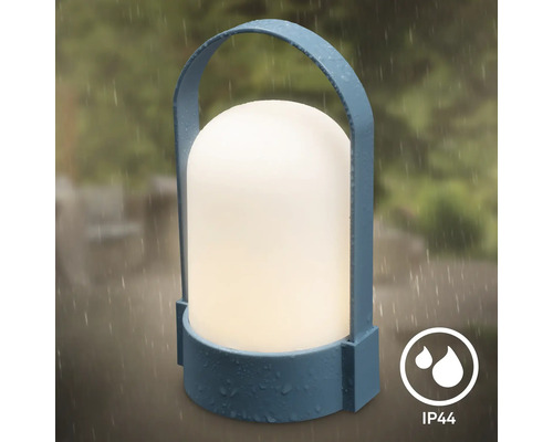 Přenosná venkovní LED lampa v modré barvě s madlem a bílým světelným tělesem, chráněná proti stříkající vodě podle IP44.