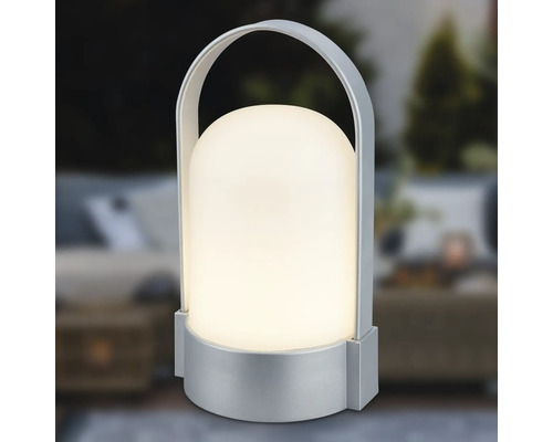 Přenosná stolní LED lampa se stříbrným podstavcem a držadlem, stínidlo ve tvaru kopule, teplé bílé světlo.