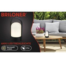 Briloner Logo, černá akumulátorová LED stolní lampa na dřevěném zahradním stole, teplé bílé světlo 3.000 Kelvinů, ochrana IP44.