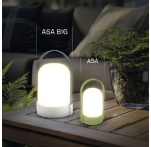 Dvě moderní přenosné LED stolní lampy ASA BIG a ASA z plastu na dřevěném stole ve světlém, organizovaném venkovním prostoru.