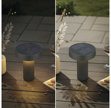 Solární stolní lampa pro venkovní použití na zahradním stole, zobrazení v osvětleném a neosvětleném stavu.