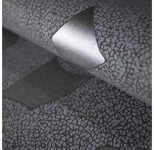 Detailní záběr tapety s texturovaným mozaikovým vzhledem a metalicky se lesknoucím prvkem.