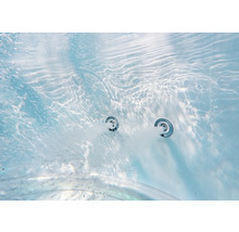 Detailní pohled pod vodou na dvě aktivní trysky vířivky s bublající vodou v bazénu nebo vaně.