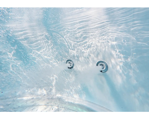 Detailní pohled pod vodou na dvě aktivní trysky vířivky s bublající vodou v bazénu nebo vaně.