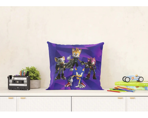 Dekorativní polštář Sonic Prime na příborníku s rostlinou, organizérem, knihami a autíčkem ve světlém prostředí.