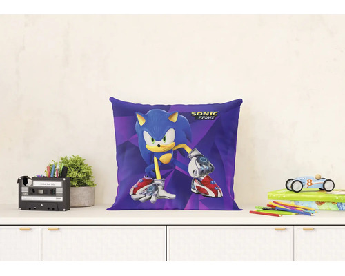 Dekorační polštář s motivem a logem Sonic Prime na bílé komodě ve světlém, organizovaném dětském pokoji s rostlinami a hračkami.