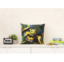 Čtvercový dekorativní polštář s postavou Transformers Bumblebee na bílé komodě v prosvětleném dětském pokoji.