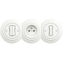 Kombinace kulatého bílého dvojitého spínače, švýcarské zásuvky typu J a jednoduchého spínače v retro designu.