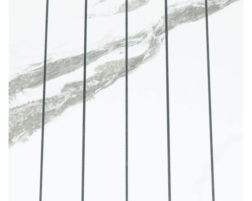 Bílý mramorový povrch s šedým žilkováním a svislými tmavými spárami.