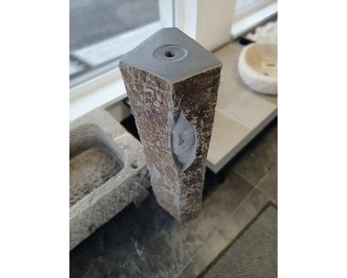 Sloupek zahradní fontány z přírodního kamene s vývrtem pro vodu v horní části.