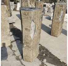Zahradní sloup z přírodního kamene s vytesaným obličejem, zahradní dekorace, kamenná skulptura.