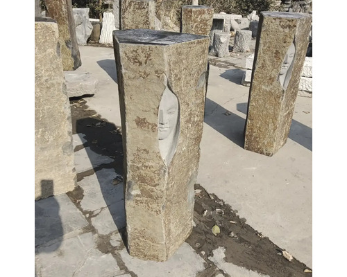 Zahradní sloup z přírodního kamene s vytesaným obličejem, zahradní dekorace, kamenná skulptura.