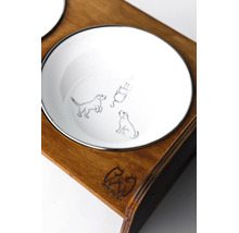 Detailní záběr na bílou misku pro psy s ilustracemi psů v tmavém dřevěném stojanu s 4PAWS Logo.