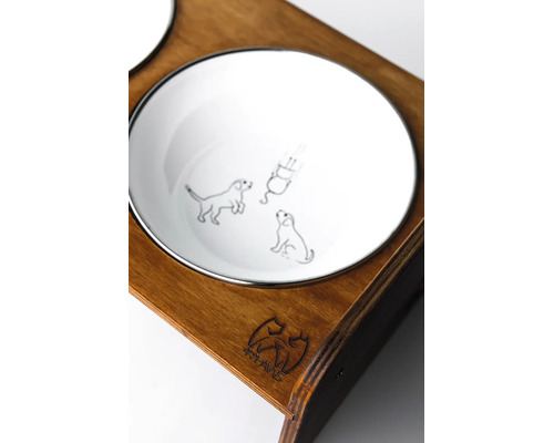 Detailní záběr na bílou misku pro psy s ilustracemi psů v tmavém dřevěném stojanu s 4PAWS Logo.