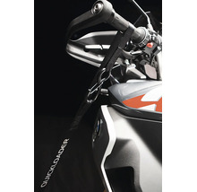 Upínací popruh Quickloader připevněný k řídítkům motocyklu pro zajištění při přepravě.
