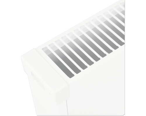 Detailní pohled na horní mřížku a bočnici bílého deskového radiátoru.