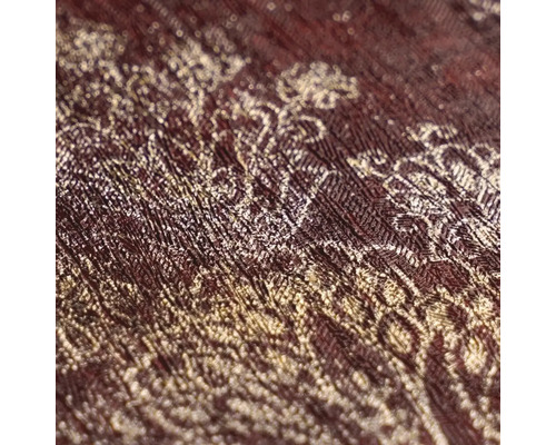 Detailní záběr vliesové tapety s ornamentálním vzorem a strukturovaným povrchem.