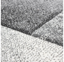 Detailní pohled na koberec s geometrickým vzorem a strukturovaným povrchem.