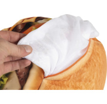 Ruka drží bílou vnitřní výplň vytaženou ze zipu plyšového hamburgeru.