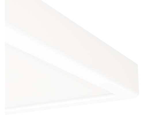 Detailní záběr na roh bílého stropního svítidla nebo LED panelu.