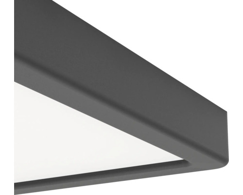 Detail rohu čtvercového stropního LED panelu s matným tmavě šedým rámem.
