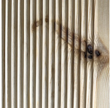 Detailní pohled na drážkovaný dřevěný povrch s viditelnými suky.