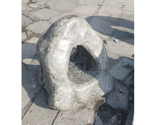 Velký zahradní kámen s přirozeným otvorem jako dekorativní prvek pro venkovní použití.