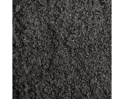 Detailní záběr jemnozrnného tmavého posypového materiálu nebo granulátu jako textury.