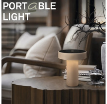 Přenosná stolní lampa na dřevěném stole v útulném obývacím pokoji.