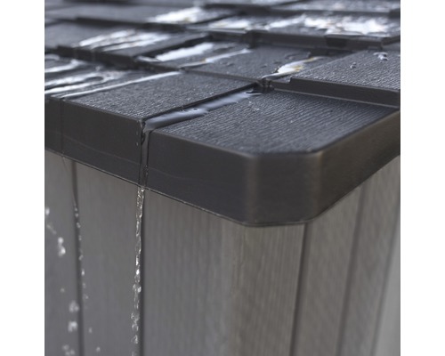 Detailní pohled na zahradní domek s vodou stékající ze střechy a stěny