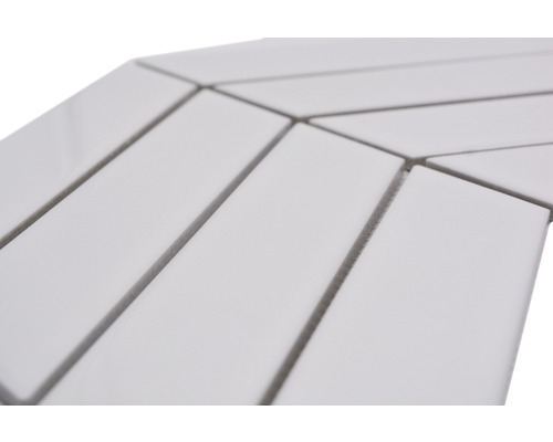 Detailní záběr obdélníkových bílých keramických dlaždic uspořádaných do vzoru rybí kosti.