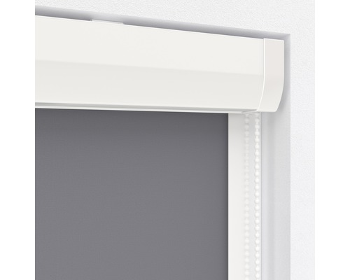 Detailní pohled na šedou roletu s bílou kazetou a ovládacím řetízkem.