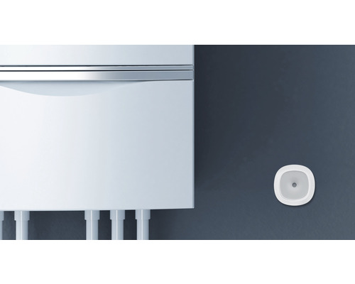 Bílý kotel s hlásičem kouře na zdi