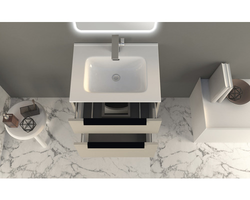 Pohled shora na umyvadlo se dvěma otevřenými zásuvkami a dekorativními předměty v koupelně